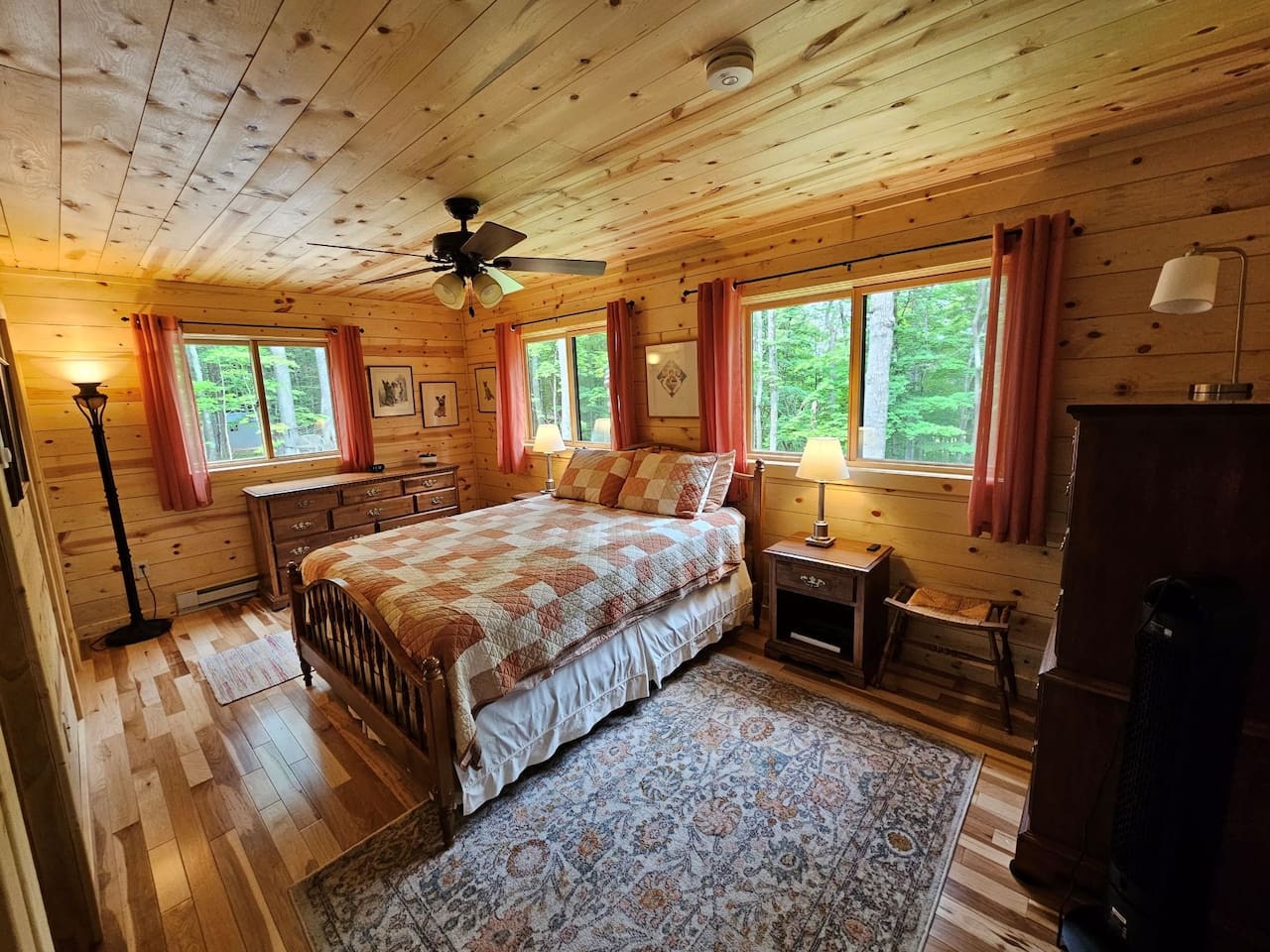 Wake up to forest views in your cozy log cabin bedroom, where rustic warmth meets modern comfort with wood ceilings and gentle morning light.