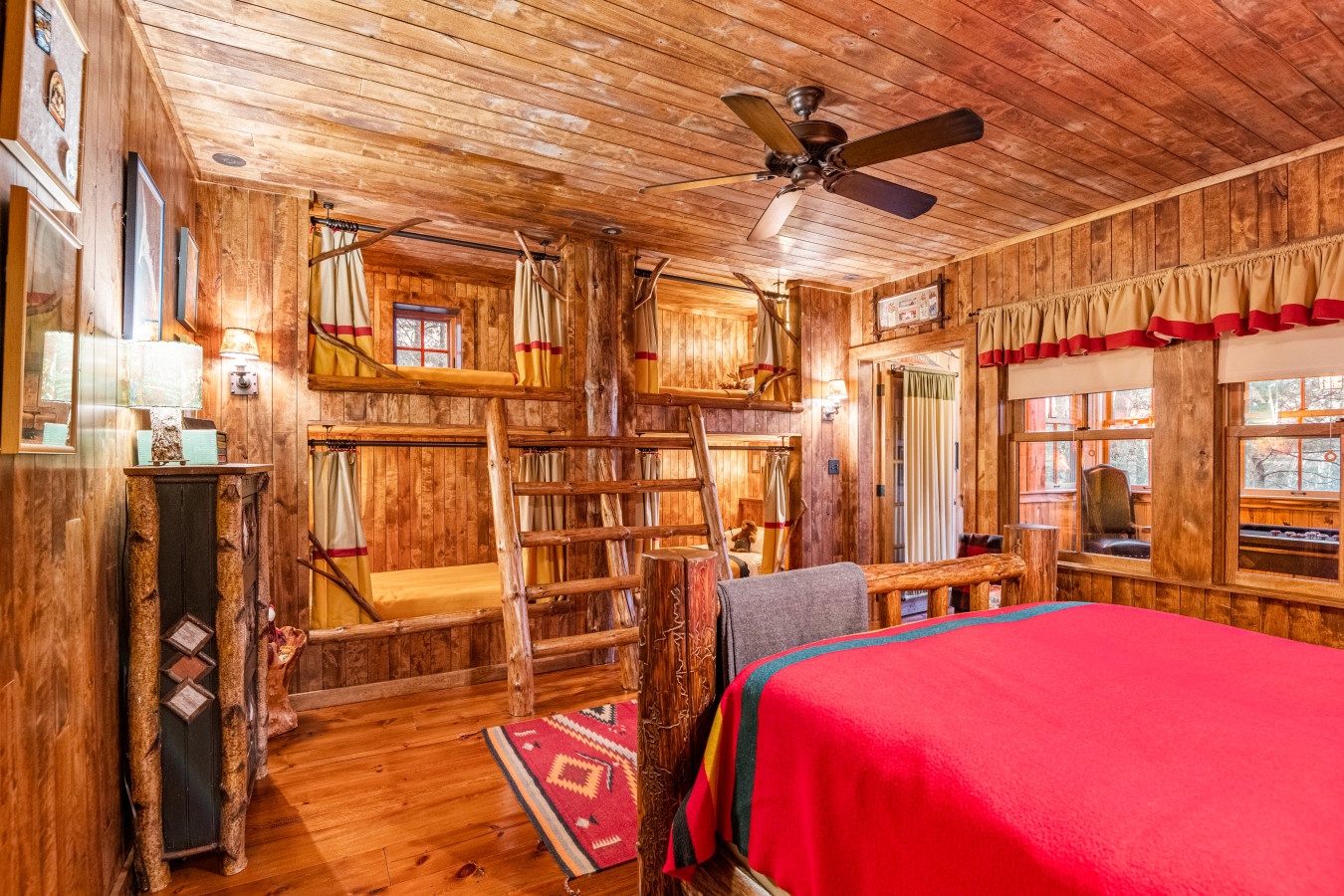 Sleep soundly in your cozy log cabin bedroom, where warm wood surrounds you and rustic bunk beds create the perfect mountain retreat atmosphere.