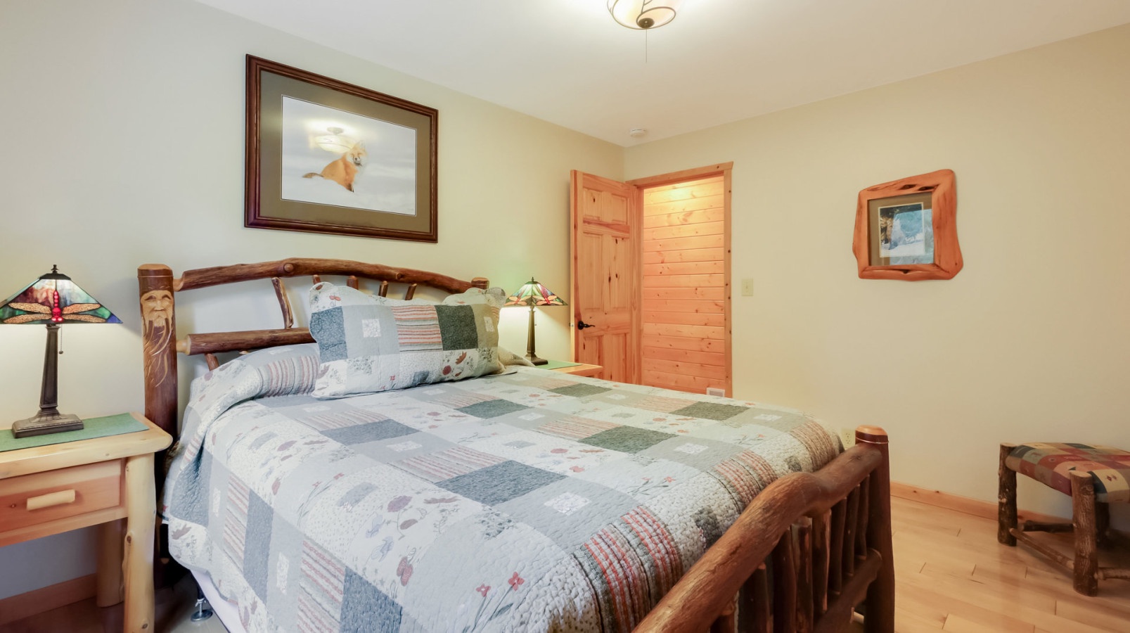 Sink into this cozy bedroom where rustic wood meets soft quilted comfort, creating your perfect mountain retreat sanctuary.
