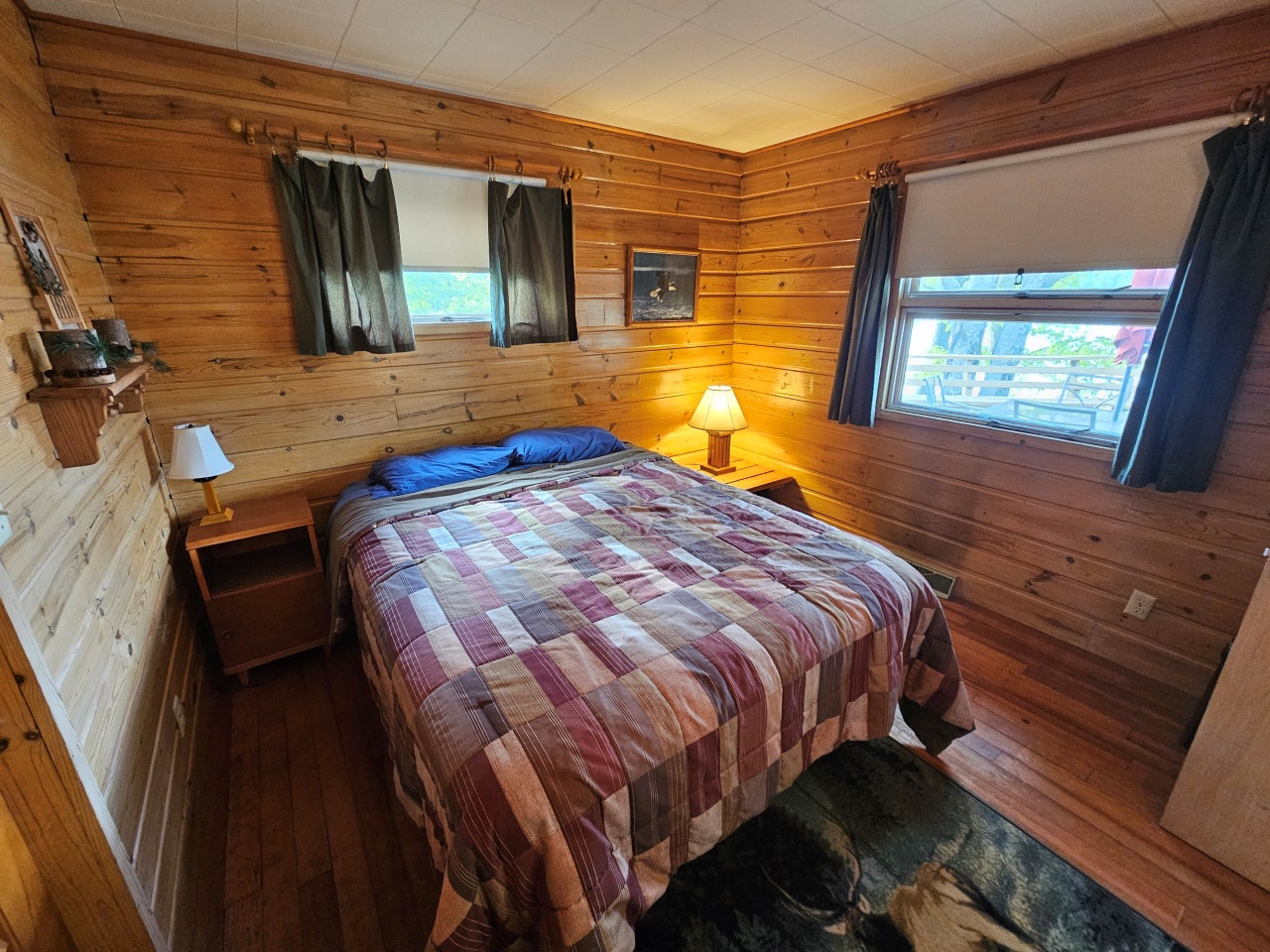 Cozy wooden cabin bedroom where natural light streams through your windows, creating a warm rustic retreat with plaid comfort.