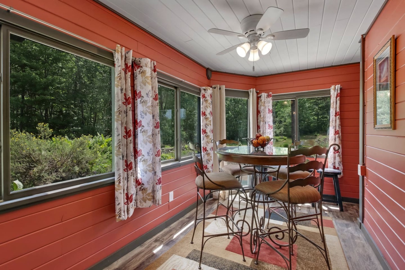 Gather for meals in your bright sunroom dining space, surrounded by peaceful garden views through wraparound windows.