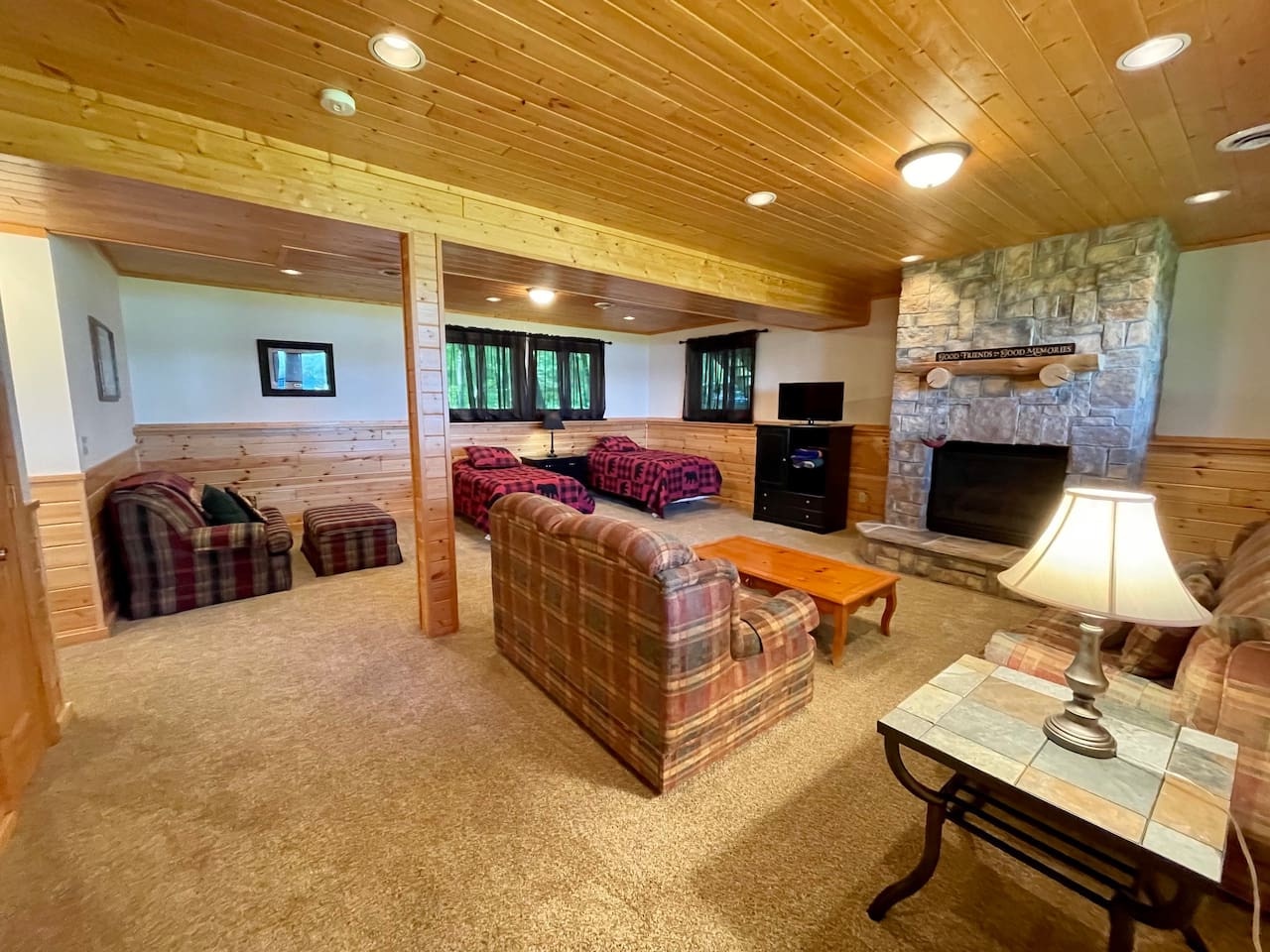Unwind in your cozy lower level retreat with warm wood beams, stone fireplace, and comfortable seating for ultimate relaxation.