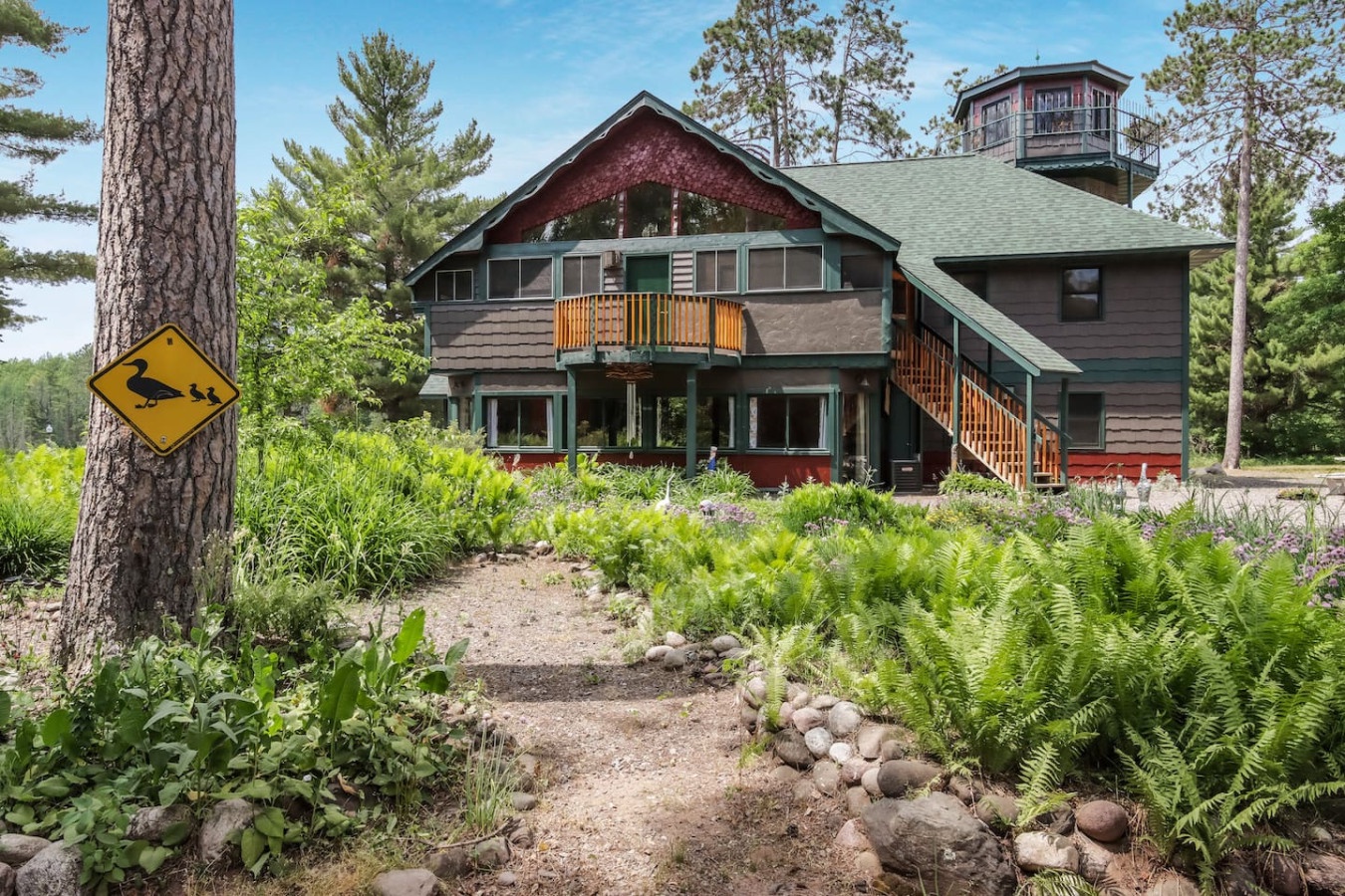 Rustic lodge nestled among towering pines and native ferns, featuring charming architectural details and peaceful forest surroundings.