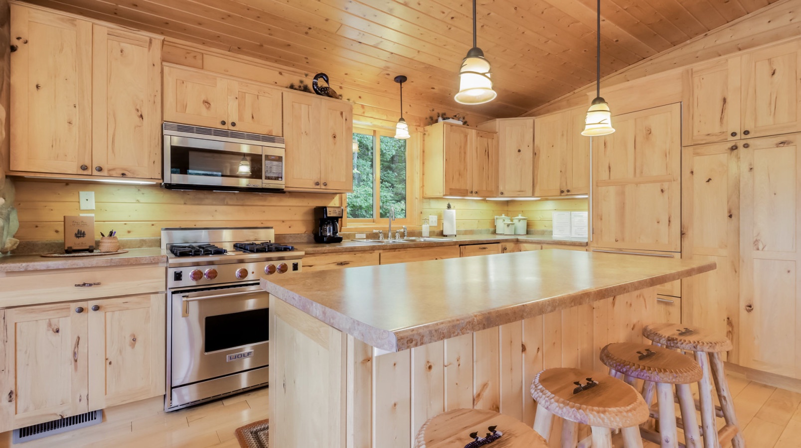 Step into your fully equipped kitchen featuring warm wood cabinets, stainless appliances, and a spacious island perfect for cooking memorable meals together.