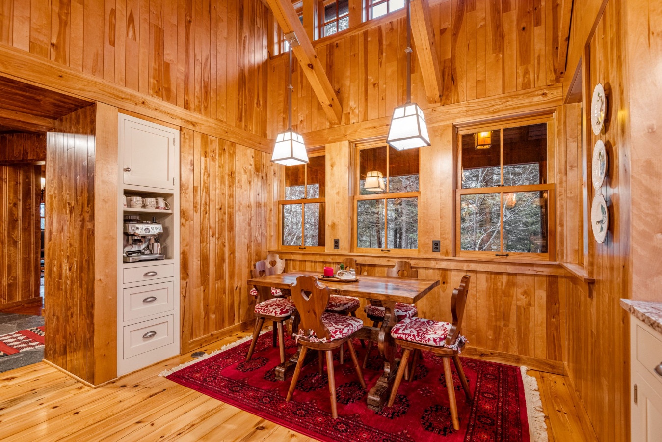 Step into your cozy alpine dining nook where warm wood surrounds you and mountain views create the perfect breakfast spot.