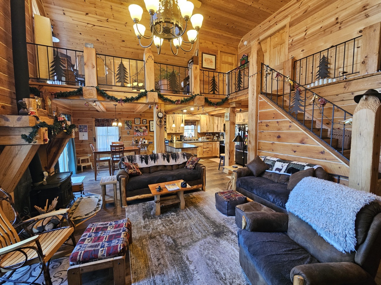 Unwind in your cozy log cabin retreat where rustic charm meets modern comfort—complete with soaring ceilings and festive holiday touches.