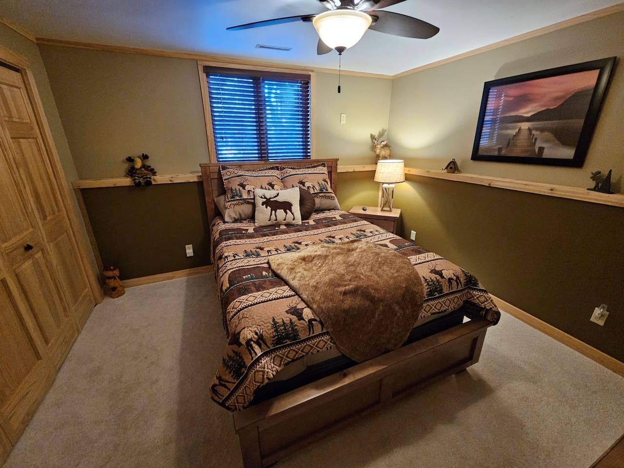 Unwind in your cozy rustic bedroom with wildlife-themed bedding and warm wood accents that create the perfect mountain retreat atmosphere.