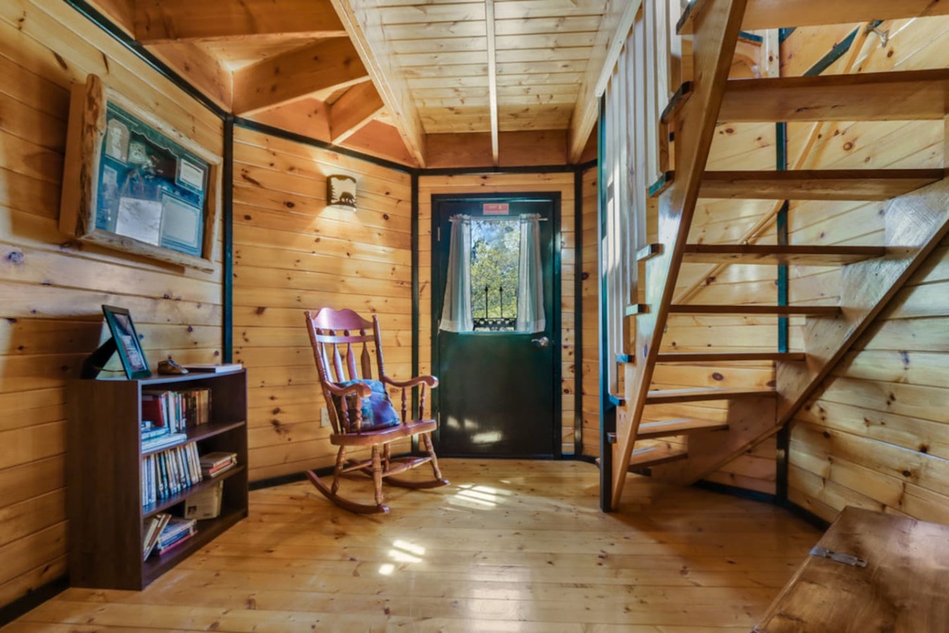 Curl up in your cozy reading chair surrounded by warm wood walls, with natural light streaming through your front door window.