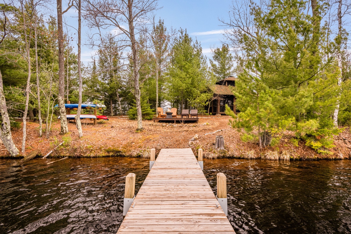 Waterfront cabin retreat with private dock, surrounded by pristine wilderness and towering pines on a peaceful lake.