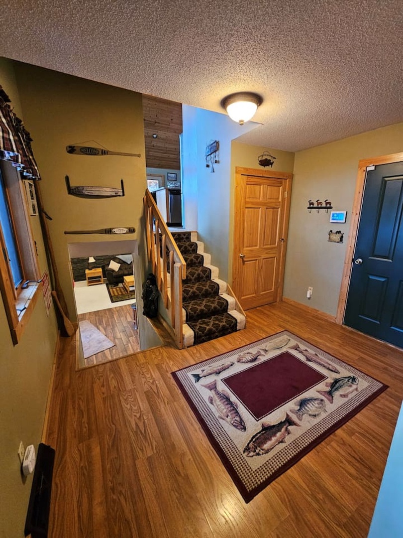 Step into your welcoming entry where rustic charm meets comfort with warm wood floors and cozy mountain-themed decor throughout.