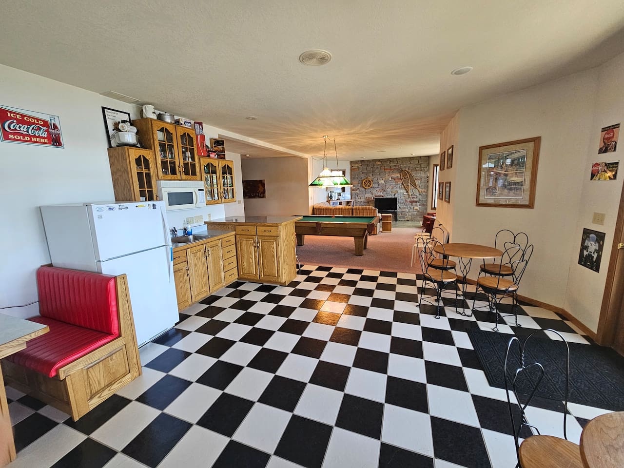 Gather around this playful rec room with classic checkered floors, full kitchen, pool table, and cozy fireplace for memorable evenings.