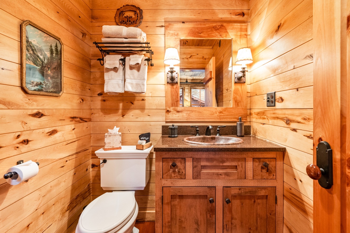 Warm wood surrounds you in this cozy bathroom, where rustic charm meets modern comfort for your mountain getaway.