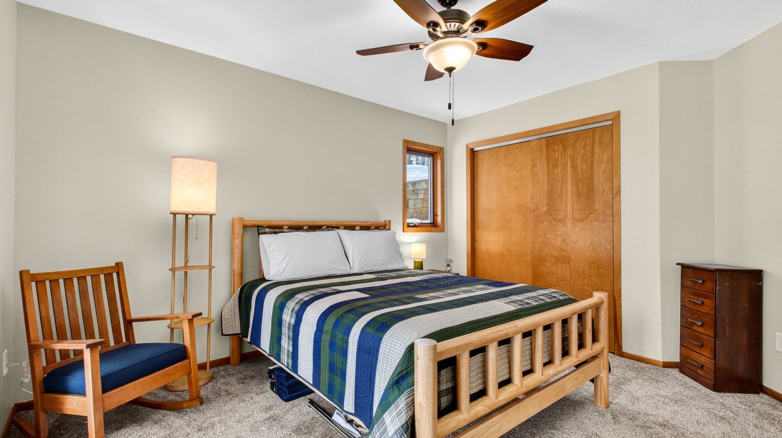 Drift off in comfort beneath the gentle ceiling fan, surrounded by warm wood accents and peaceful natural light streaming through your window.