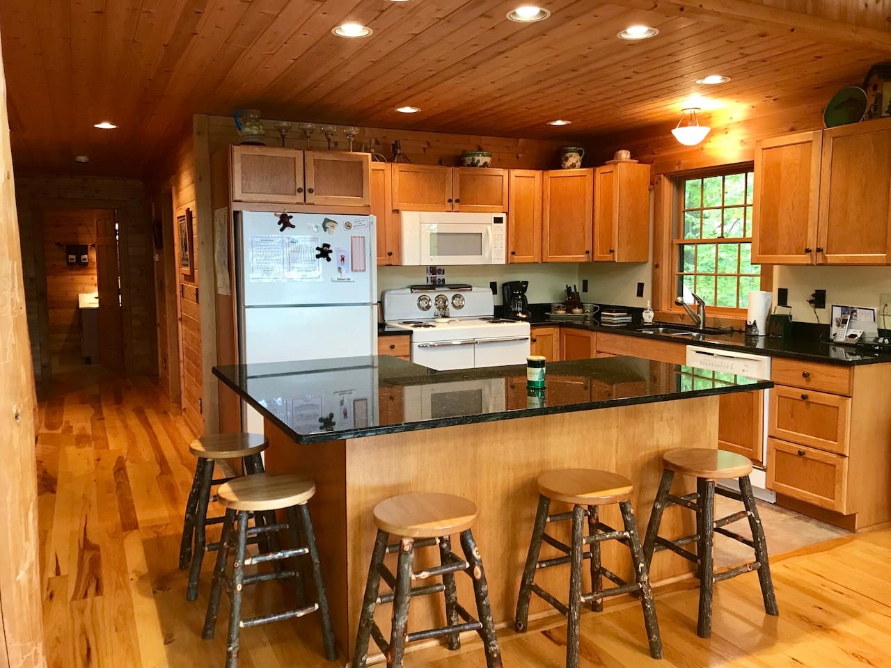 Your fully equipped cabin kitchen features granite counters and rustic wood charm, perfect for preparing meals during your mountain getaway.