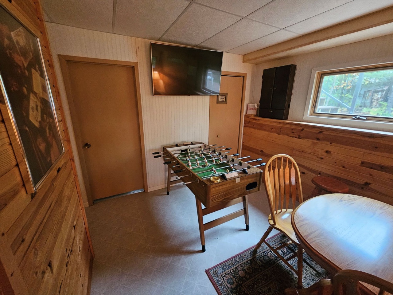 Challenge friends to foosball in your cozy game room, complete with a large TV for movie nights and rustic wood accents.
