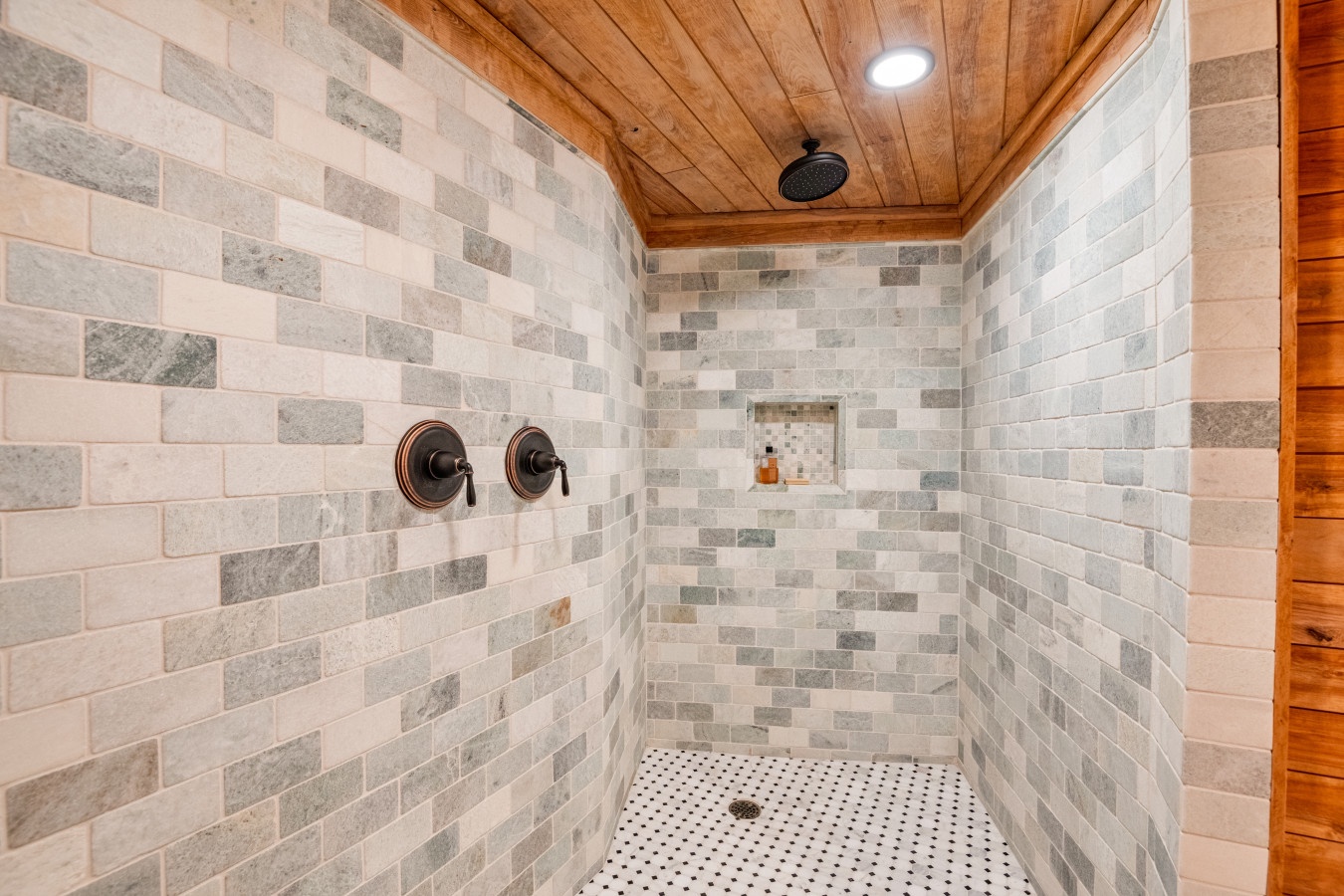 Step into your private spa-like shower with stunning natural stone walls and warm wood ceiling for the ultimate relaxation.