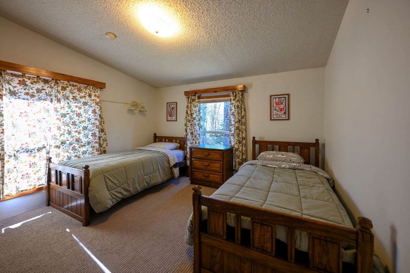 Your peaceful twin bedroom features solid wood furniture and cheerful floral curtains, creating a cozy retreat for restful nights.