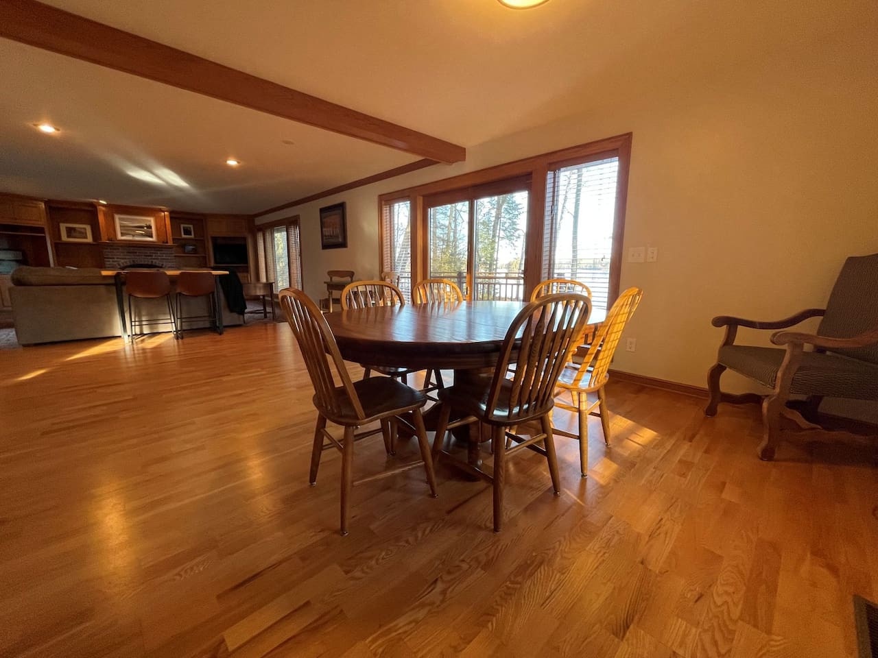 Gather around this spacious dining table where your group can share meals and make memories. The warm wood floors and natural light create the perfect atmosphere.