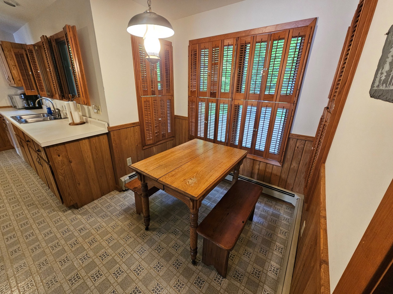 Gather around this charming dining nook where rich wood details and warm shutters create the perfect spot for your morning coffee or evening meals together.