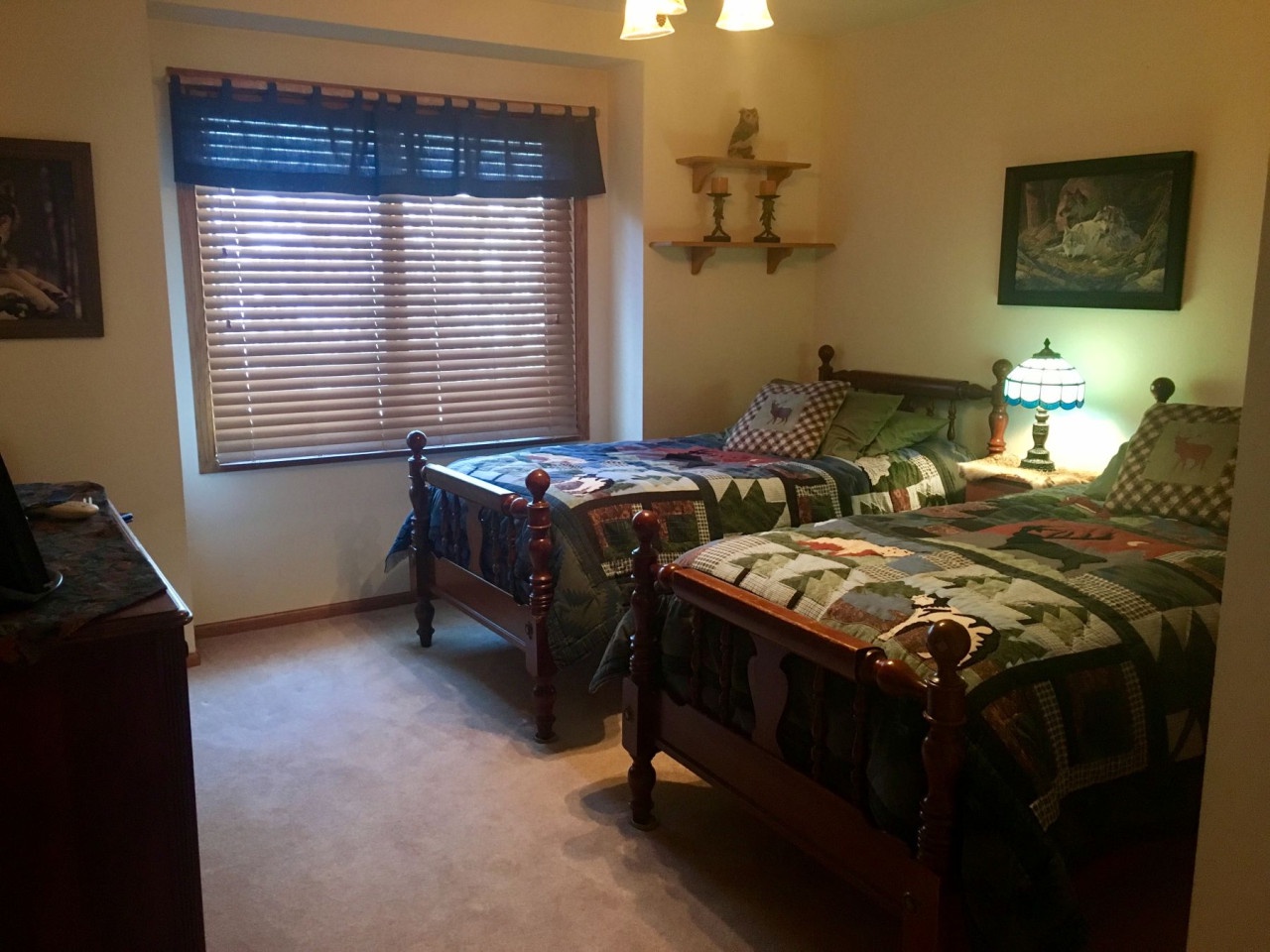 Cozy twin beds with charming quilted spreads create the perfect spot for restful nights, while warm lighting makes your evening wind-down feel wonderfully peaceful.