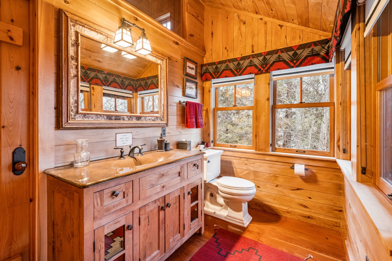 Rustic charm meets comfort in this beautifully appointed bathroom where warm wood surrounds you in cabin elegance.
