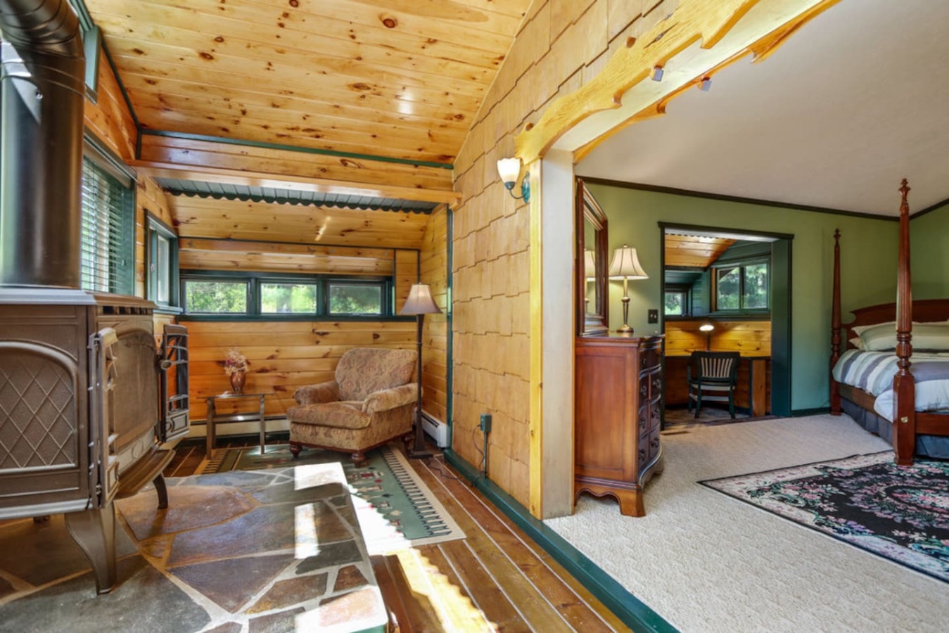 Unwind in your rustic retreat with warm log walls, a cozy reading chair by the fireplace, and classic cabin charm throughout.