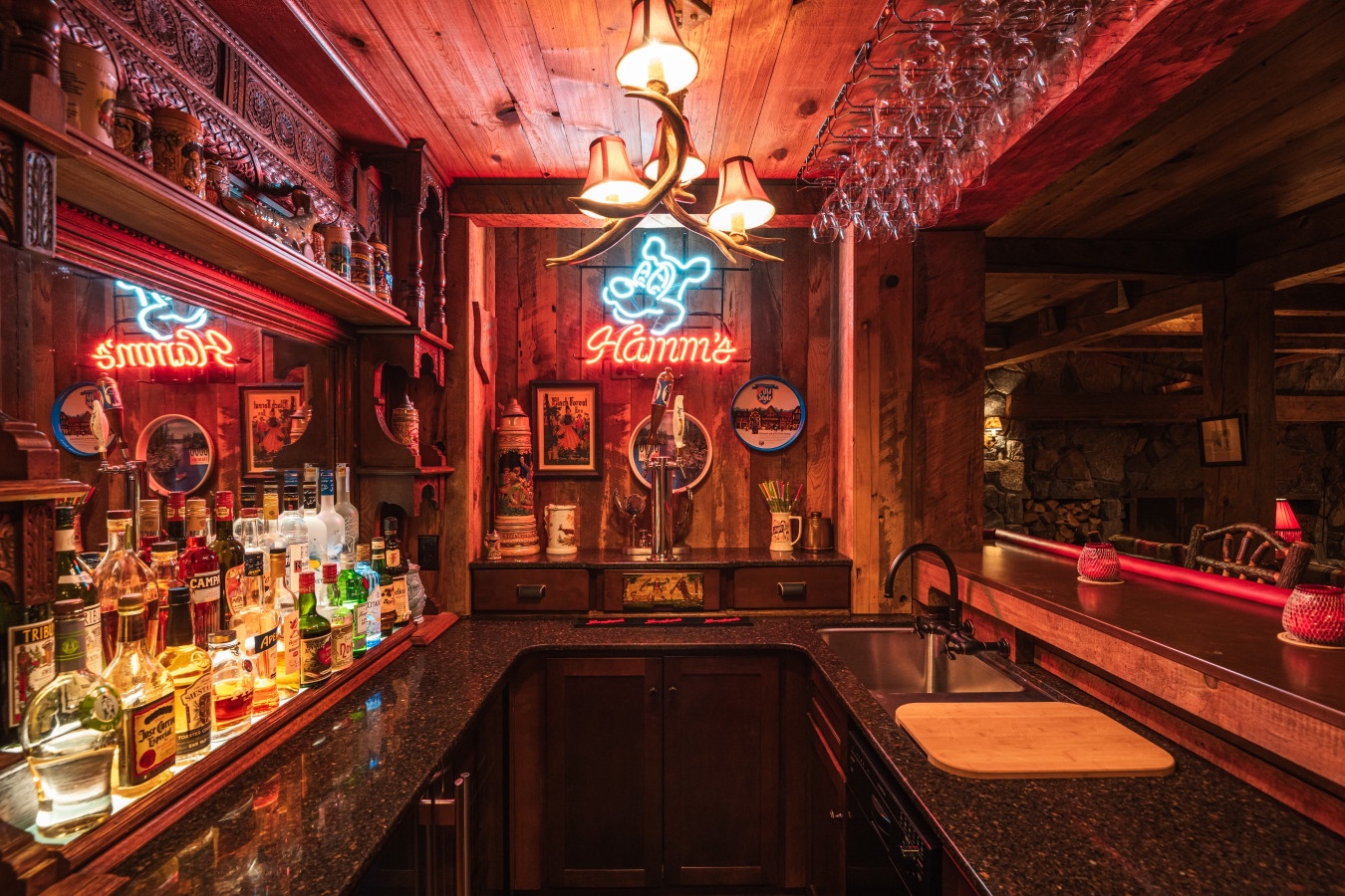 Step into your private rustic bar where neon signs cast warm glows over vintage memorabilia and premium spirits await your evening enjoyment.