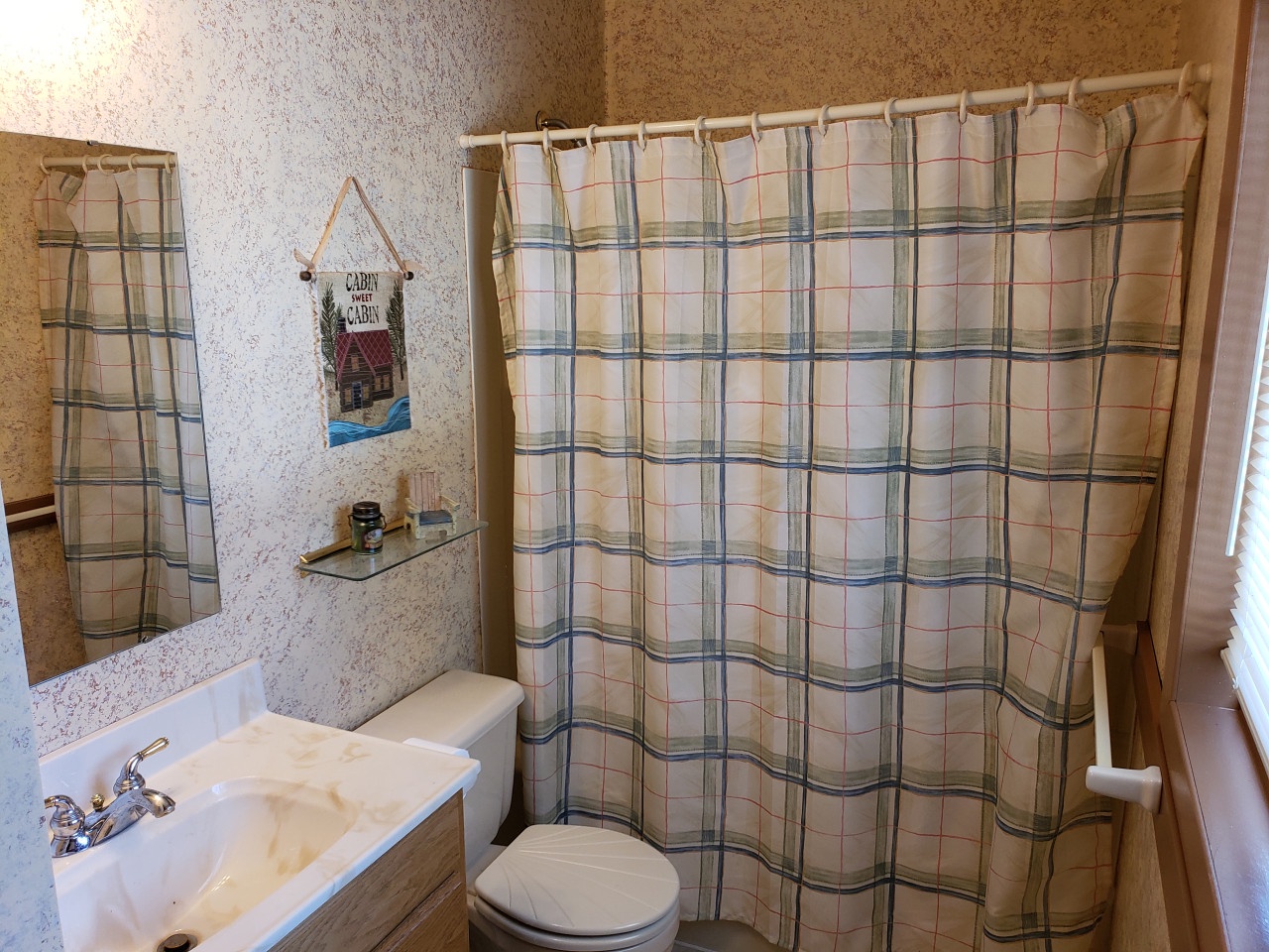 Unwind in your private bathroom featuring a soaking tub, shower combo, and charming cottage touches that make freshening up feel like home.