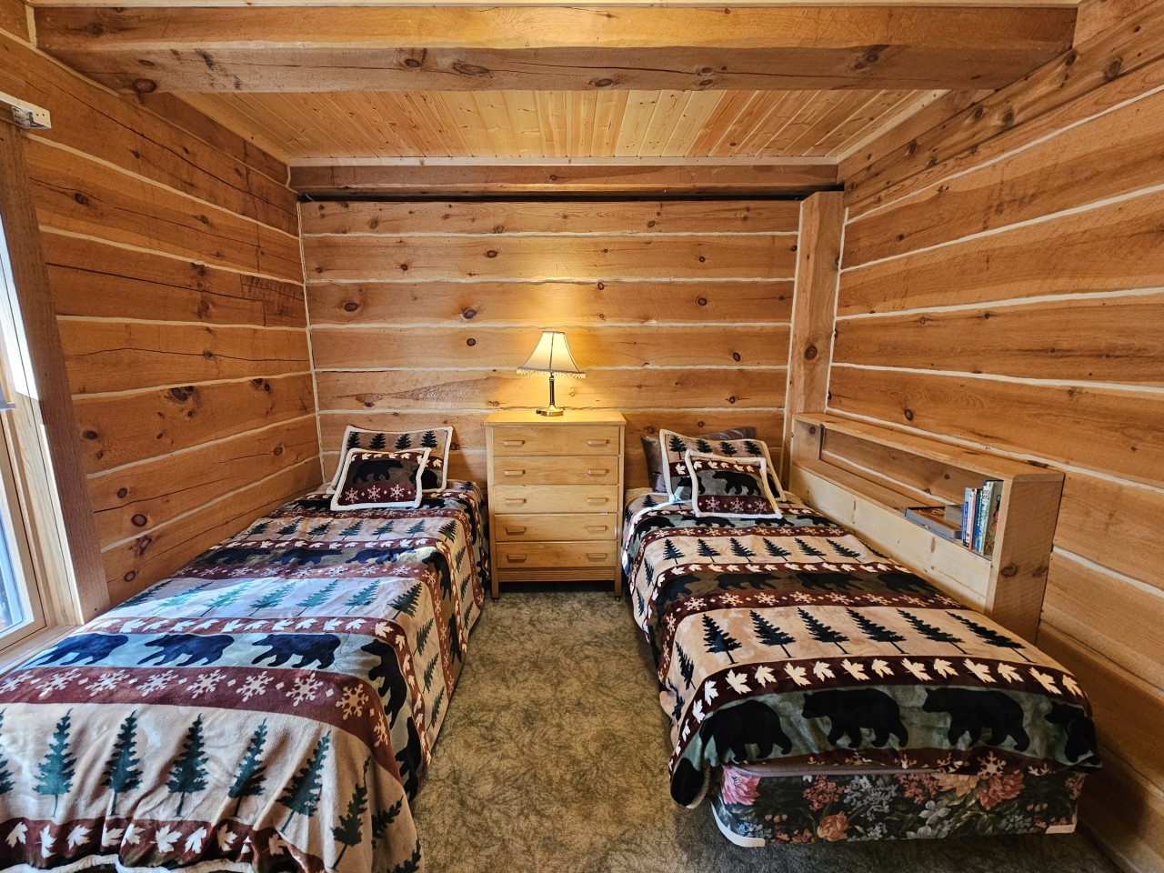 Cozy up in this charming twin bedroom with rustic log walls and colorful southwestern bedding that wraps you in mountain lodge comfort.