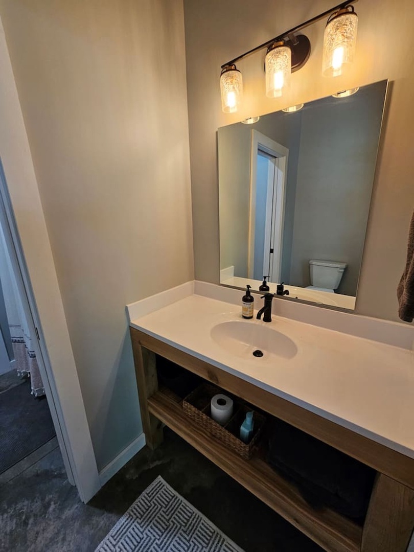 Step into your beautifully appointed bathroom featuring warm wood vanity, modern fixtures, and stylish lighting that creates the perfect ambiance for your morning routine.