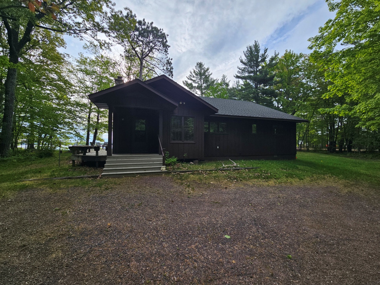 A charming woodland cabin surrounded by lush green trees offering peaceful forest retreat.