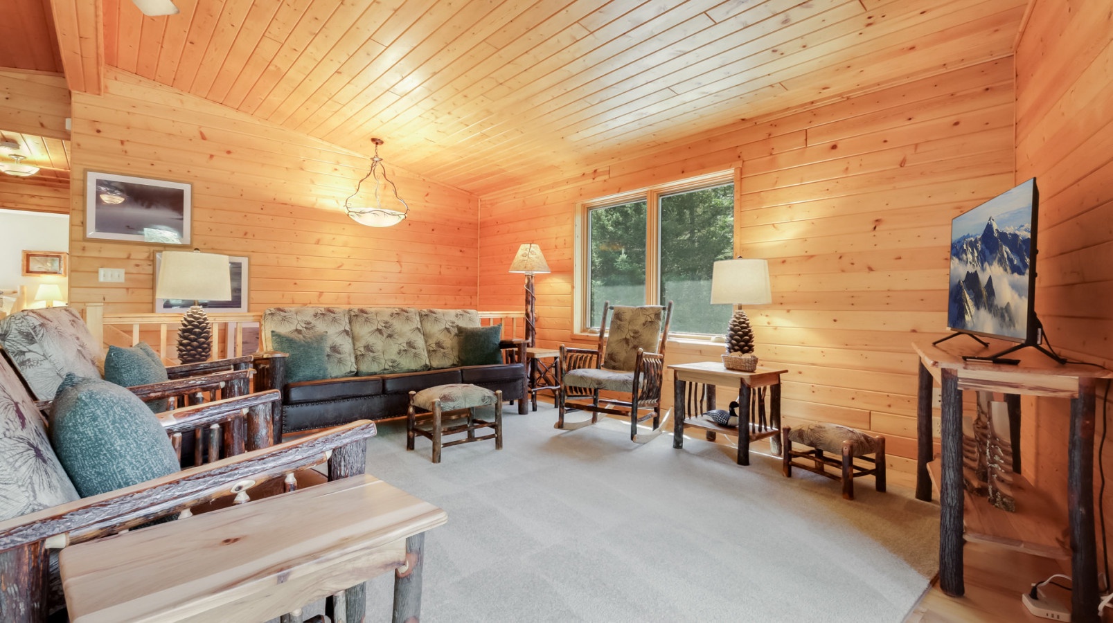 Step into your cozy cabin retreat where warm pine walls and rustic log furniture create the perfect mountain escape for relaxing evenings.