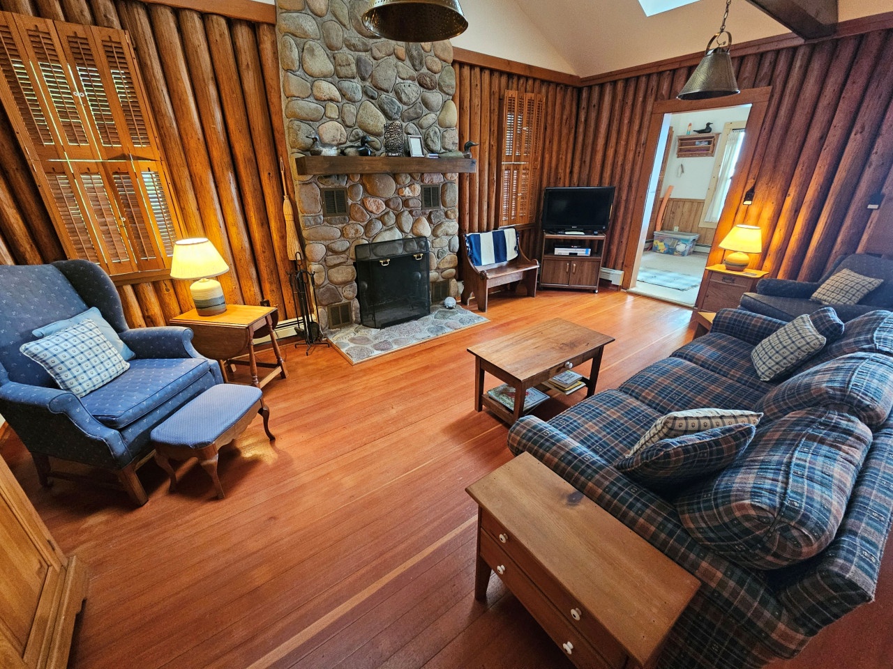 Unwind in your cozy cabin living room with a stunning stone fireplace and warm wood finishes creating the perfect mountain retreat.