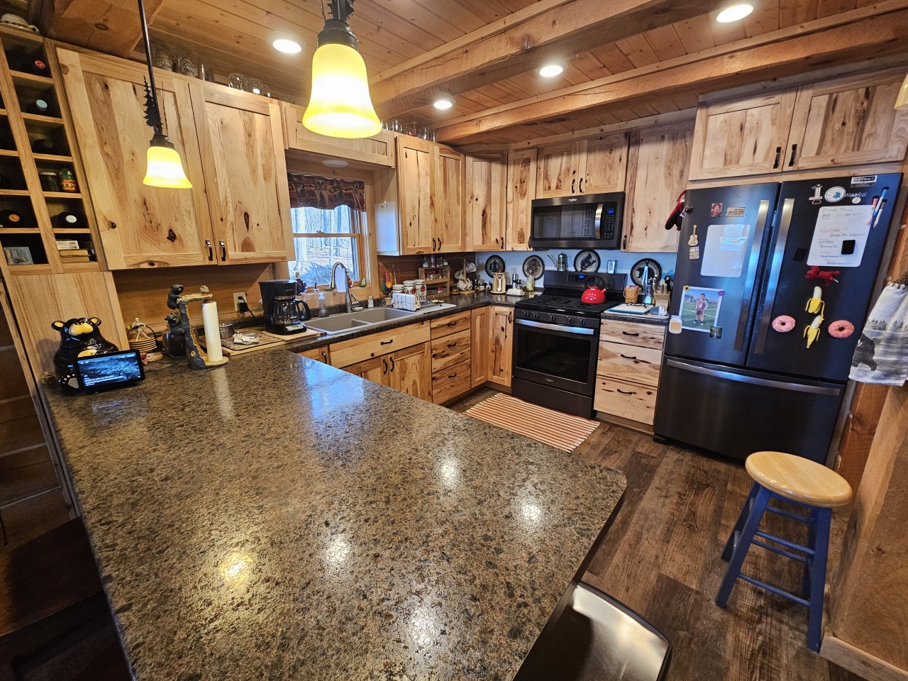 Cook your favorite meals in this rustic kitchen featuring warm wood cabinets, granite counters, and modern appliances.