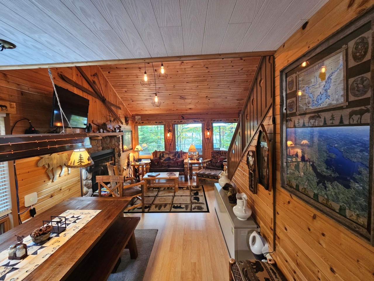 Unwind in this rustic cabin's cozy living space, where warm wood surrounds you and nature views fill every window.