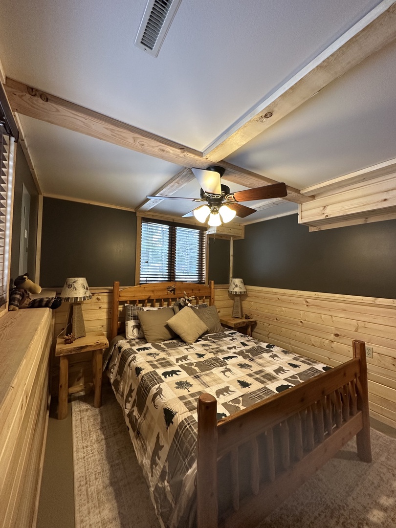 Cozy rustic bedroom with authentic log bed, exposed beams, and charming wildlife-themed décor creates your perfect cabin retreat.