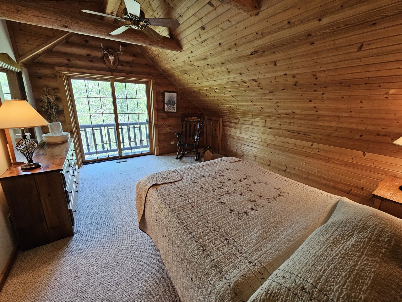 Unwind in your cozy attic bedroom where rustic wood beams frame peaceful moments and your private balcony invites morning coffee rituals.