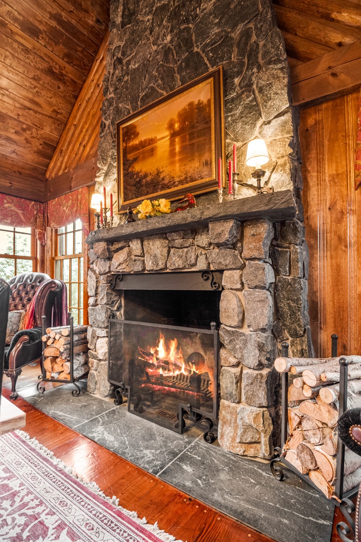 Curl up by your crackling stone fireplace, where warm flames dance against rustic log walls and cozy furnishings invite evening relaxation.