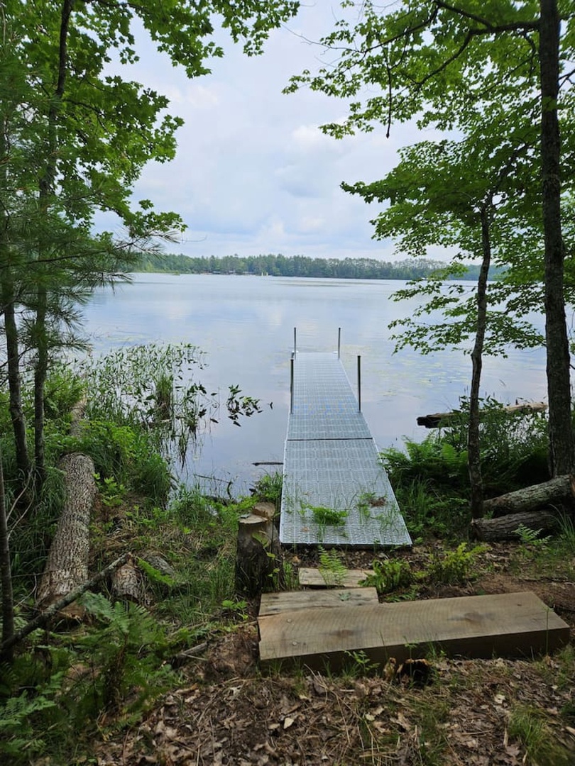 A peaceful lake surrounded by lush forest creates the perfect natural retreat just steps from the property.