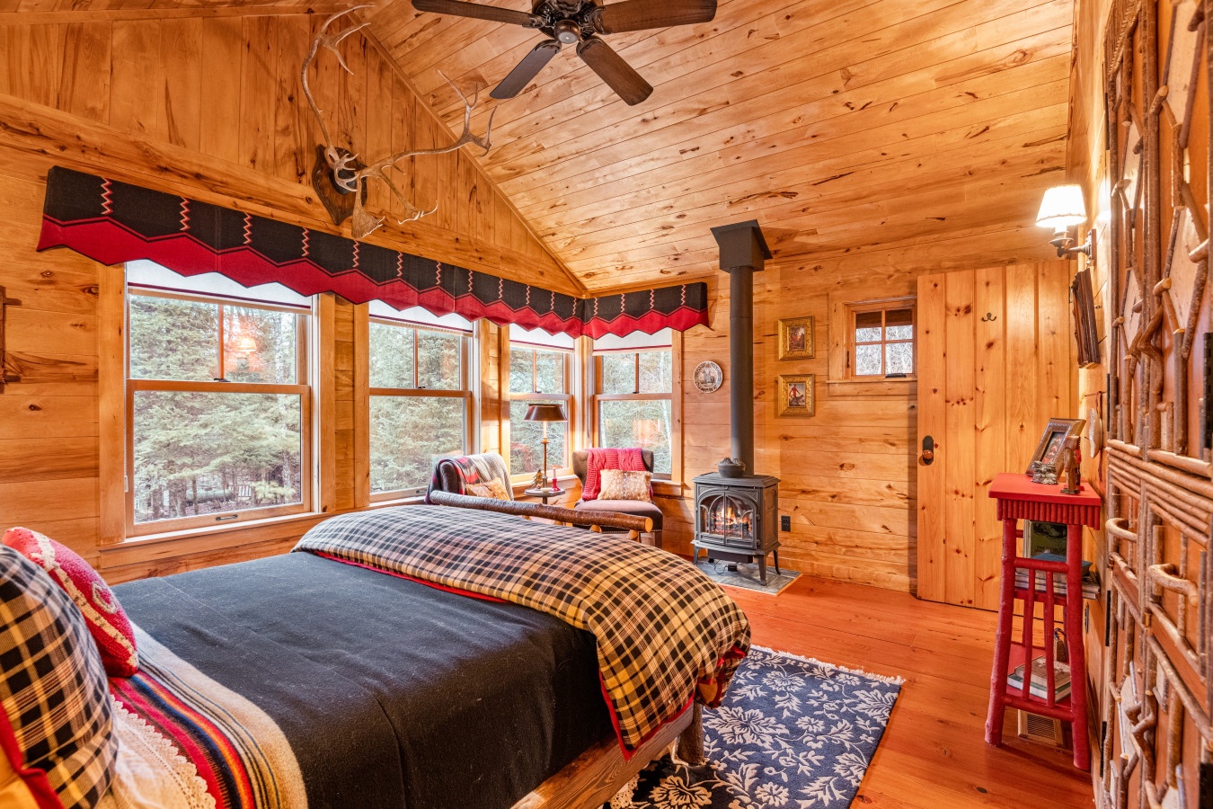 Cozy up in your rustic cabin bedroom where warm wood surrounds you and a crackling fireplace sets the perfect mood for mountain relaxation.