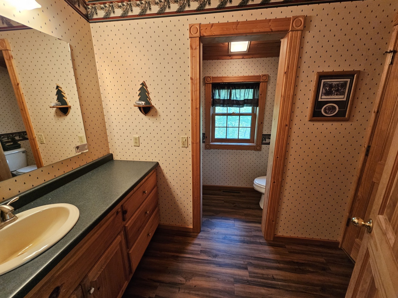 Step into your private bathroom with charming country details, rich wood flooring, and a separate toilet room for added convenience during your stay.