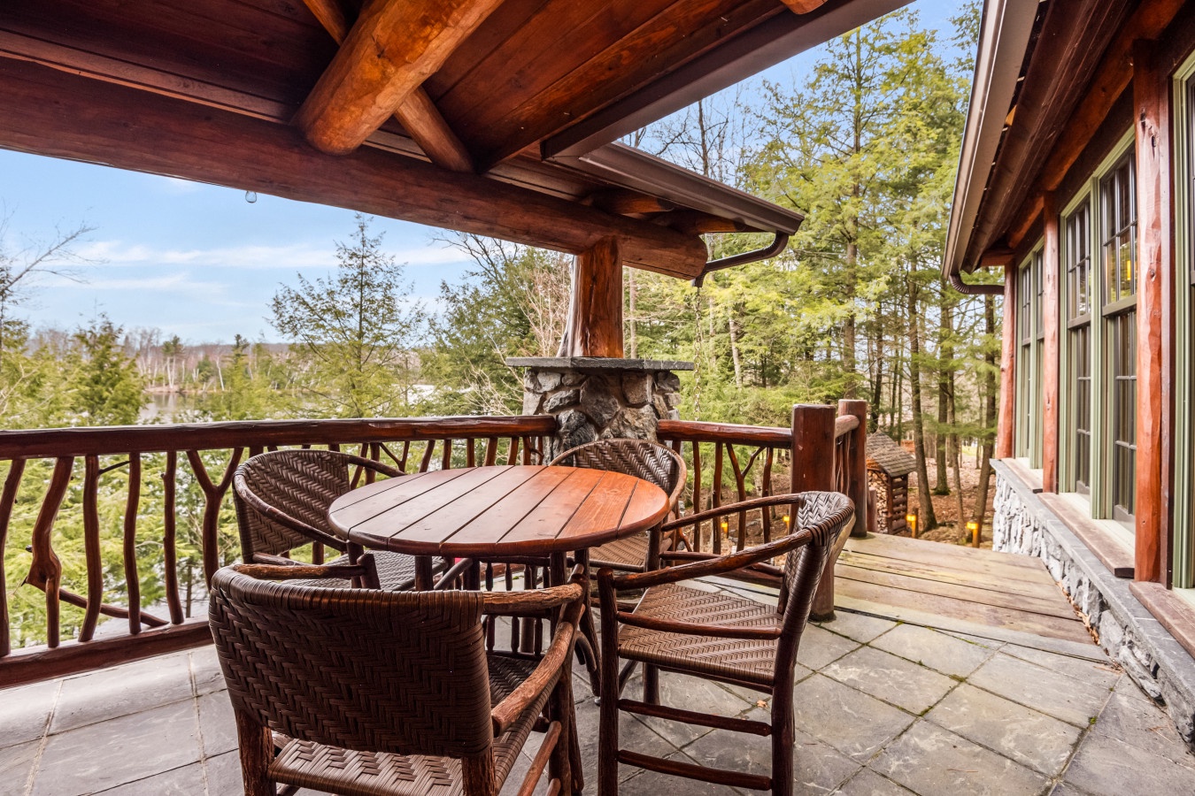 Relax on your private covered terrace with rustic wood beams overhead, enjoying forest views while dining at your intimate table for four.