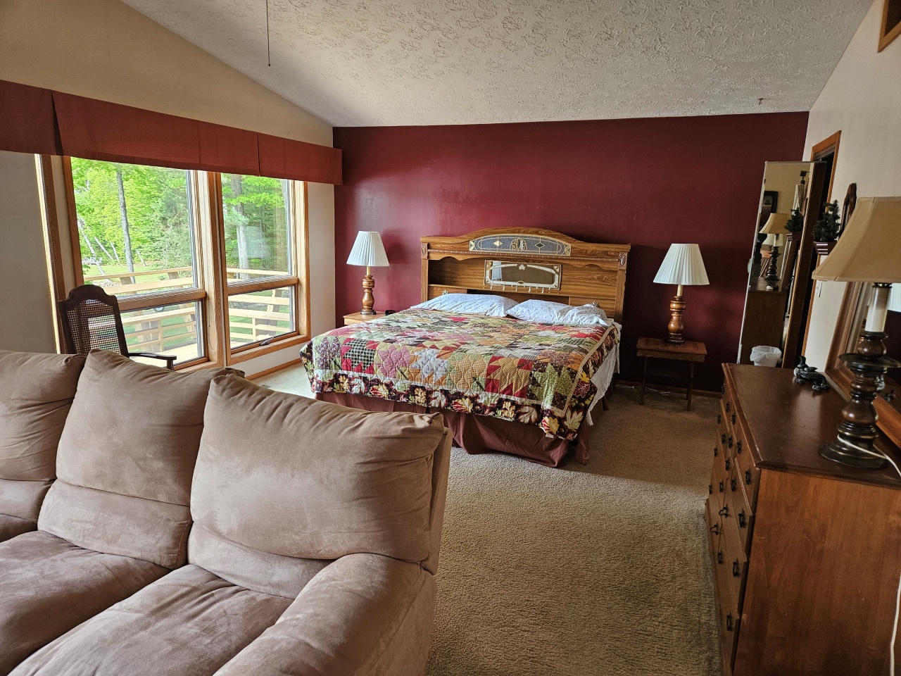 Unwind in your spacious suite with rich burgundy accents, plush seating, and warm wood furnishings creating the perfect retreat.