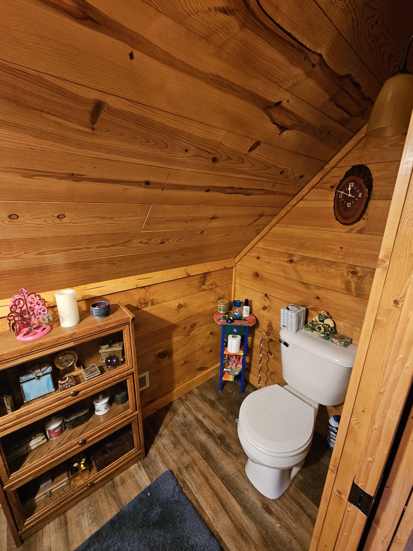 Your private rustic bathroom features warm wood paneling and thoughtful storage for a cozy mountain retreat experience.