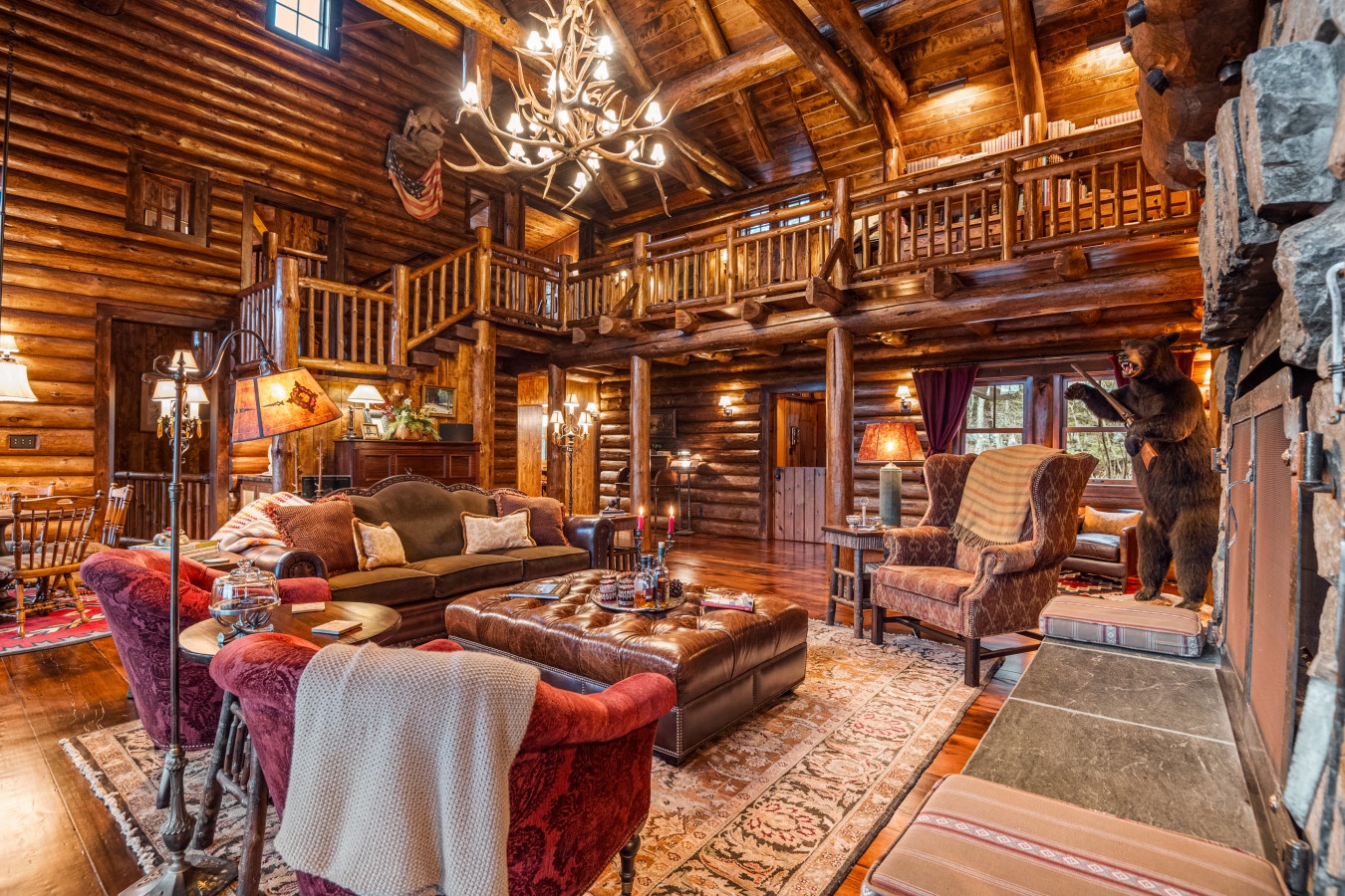 Sink into rich leather sofas by your crackling fireplace in this grand log cabin living room with soaring ceilings and rustic charm.