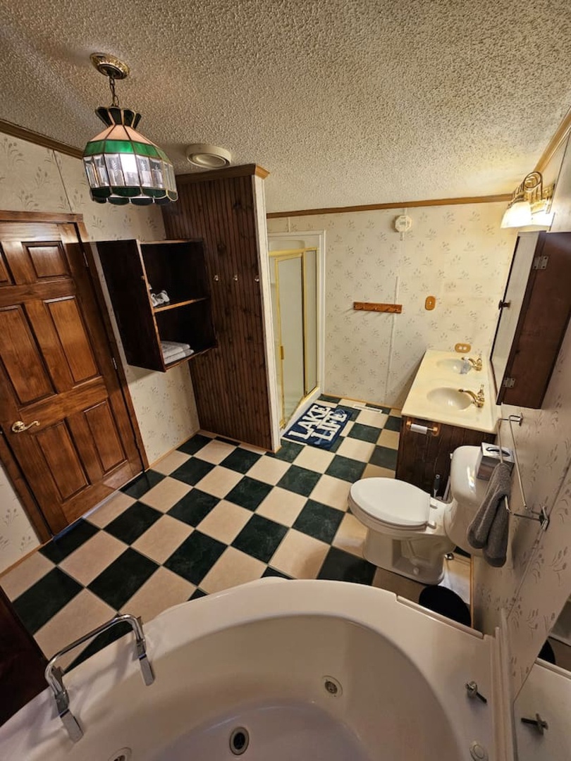 Your private bathroom features a relaxing jetted tub, classic checkerboard floors, and vintage charm with modern amenities.