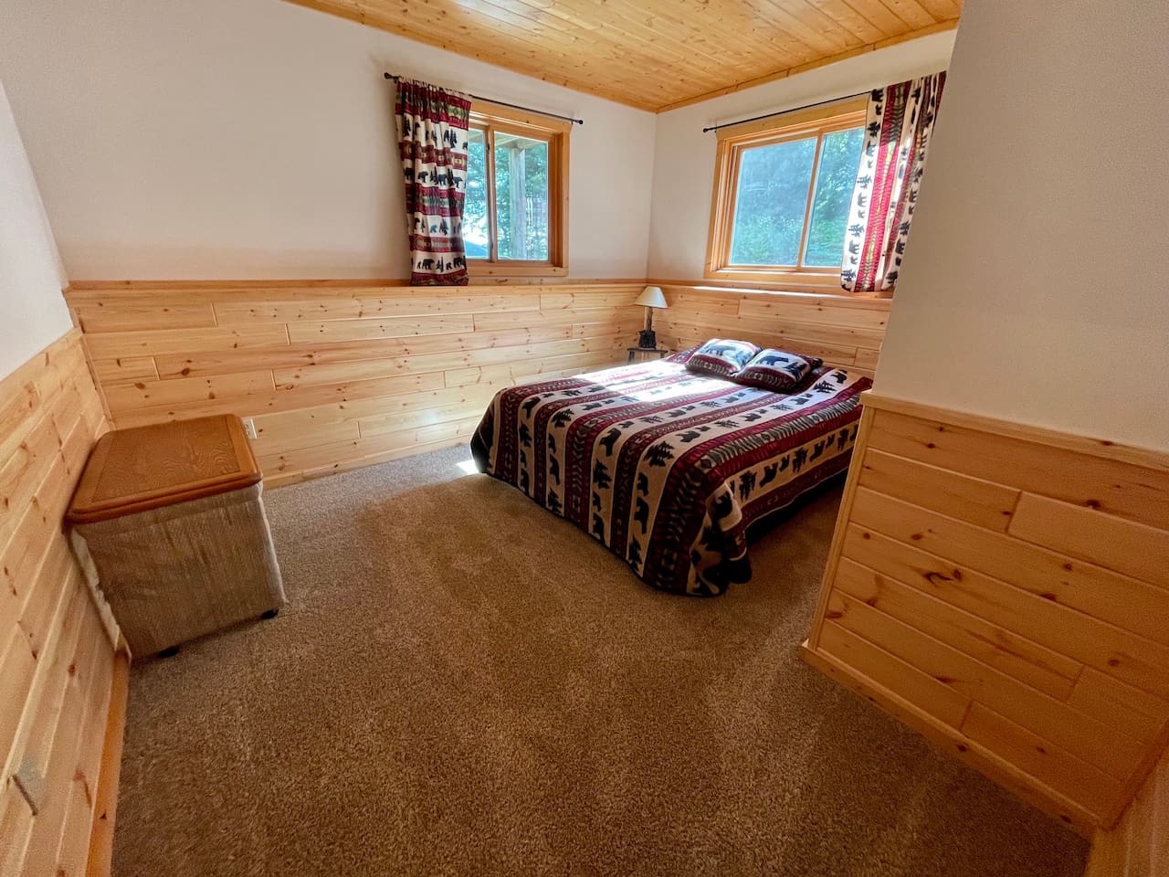 Drift off to sleep in your cozy alpine bedroom, where warm wood walls and Native American-inspired bedding create a serene mountain retreat.