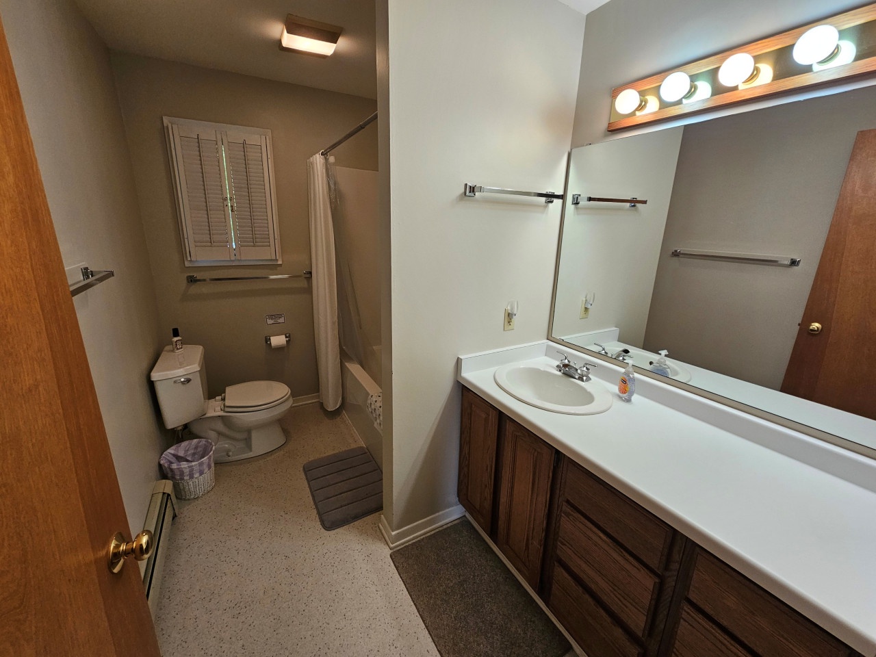 Your private bathroom features a spacious vanity with bright Hollywood-style lighting and a separate toilet area for added convenience.
