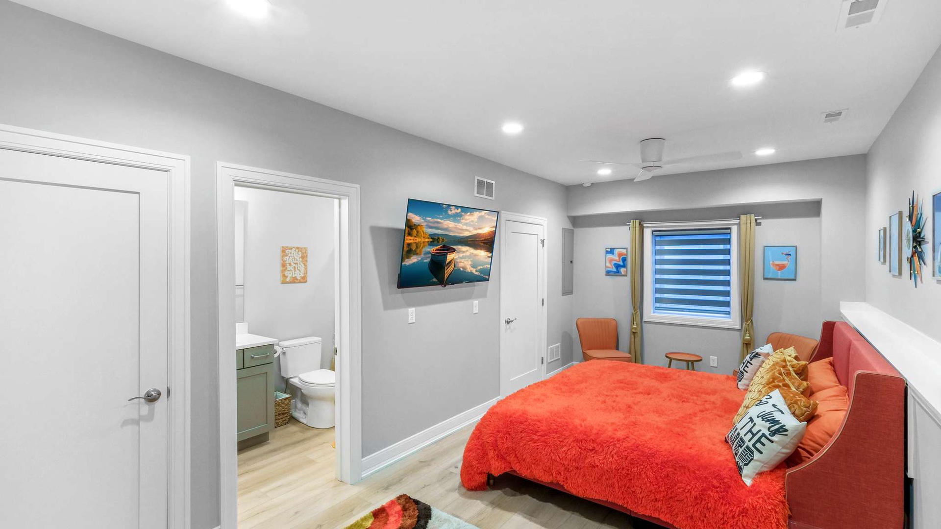 Sink into plush coral bedding while catching up on your favorite shows on the wall-mounted TV in this bright, modern bedroom.