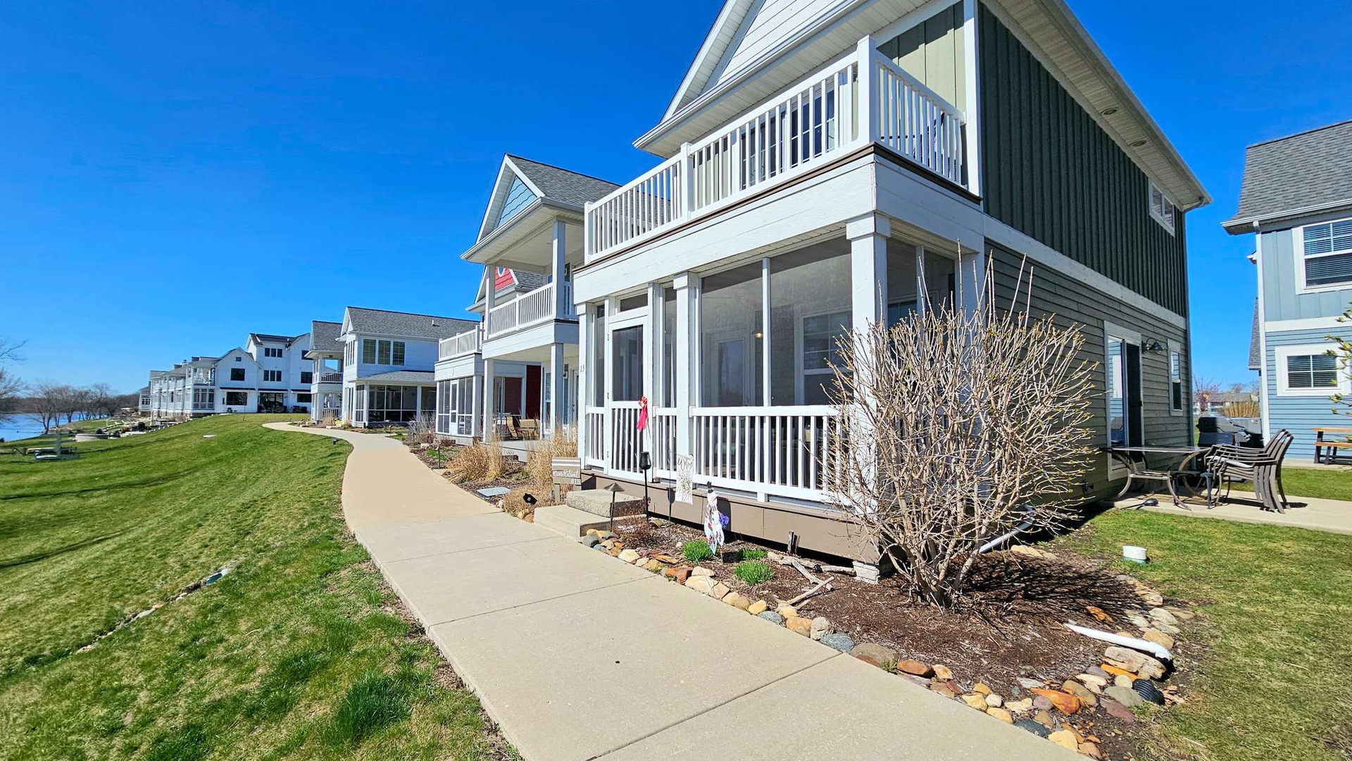 Charming lakeside cottage community with coastal-style architecture, manicured lawns, and waterfront access creating an ideal vacation retreat setting.